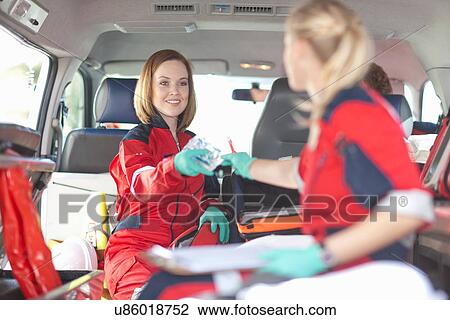 Paramedics in ambulance checking medical equipment View Large Photo Image Stock Image - Paramedics in ambulance checking medical equipment. Fotosearch