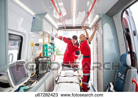 Paramedics in ambulance preparing medical equipment View Large Photo Image Stock Image - Paramedics in ambulance preparing medical equipment. Fotosearch