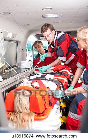 Paramedics with intravenous drip and patient in ambulance View Large Photo Image Picture - Paramedics with intravenous drip and patient in ambulance. Fotosearch