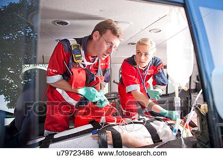 Paramedics working on patient in ambulance View Large Photo Image Stock Photograph - Paramedics working on patient in ambulance. Fotosearch