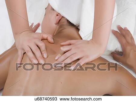 Stock Image - Person massaging woman's shoulders. Fotosearch
