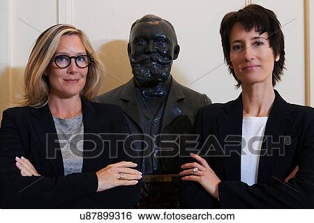Portrait of confident professional women next to statue View Large Photo Image Stock Photograph - Portrait of confident professional women next to statue. Fotosearch