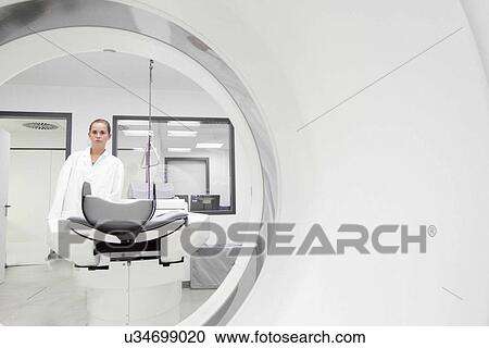 Stock Image - Portrait of female doctor through ct scanner. Fotosearch