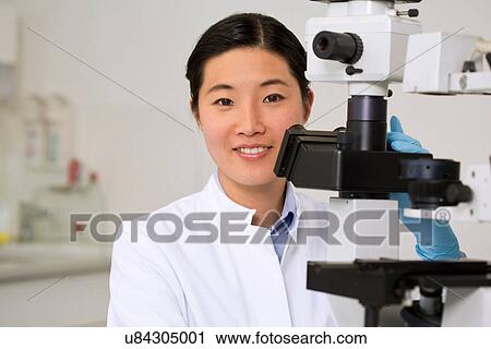 Portrait of female scientist working in laboratory with microscope View Large Photo Image Stock Image - Portrait of female scientist working in laboratory with microscope. Fotosearch