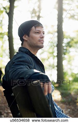 Portrait of man sitting on bench in autumn View Large Photo Image Stock Photo - Portrait of man sitting on bench in autumn. Fotosearch