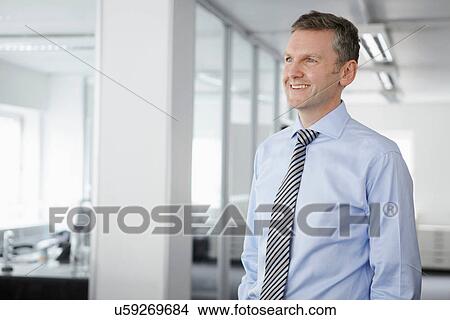 Portrait of mature businessman in office, looking away View Large Photo Image Picture - Portrait of mature businessman in office, looking away. Fotosearch