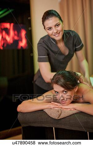 Stock Photo - Portrait of mid adult woman and masseur in treatment room. Fotosearch