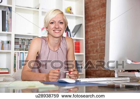Stock Photo - Portrait of mid adult woman at desk. Fotosearch