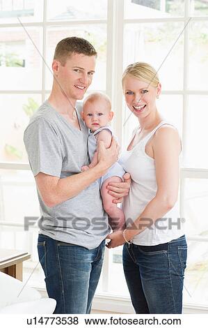 Portrait of parents holding baby View Large Photo Image Stock Photo - Portrait of parents holding baby. Fotosearch