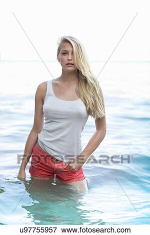 Stock Photo - Portrait of sultry young woman standing in lake. Fotosearch