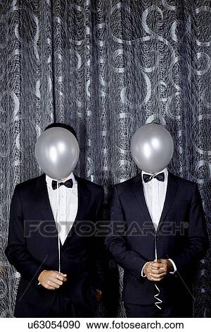 Portrait of two young men with balloons in front of faces View Large Photo Image Stock Image - Portrait of two young men with balloons in front of faces. Fotosearch