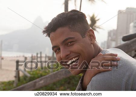 Picture - Portrait of young man with short black hair, smiling. Fotosearch