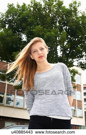 Stock Image - Portrait of young woman outdoors, low angle. Fotosearch