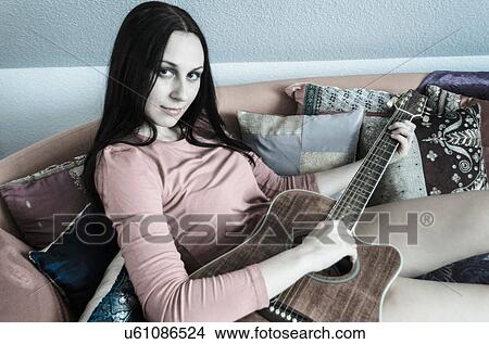 Picture - Portrait of young woman playing guitar. Fotosearch
