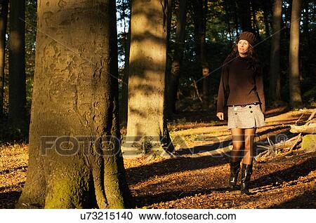 Portrait of young woman walking in forest View Large Photo Image Stock Image - Portrait of young woman walking in forest. Fotosearch