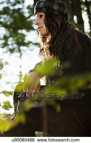 Portrait of young woman wearing hat, looking away View Large Photo Image Stock Photo - Portrait of young woman wearing hat, looking away. Fotosearch