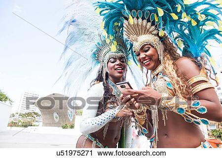 Stock Image - Samba dancers using cellphone, Rio De Janeiro, Brazil. Fotosearch