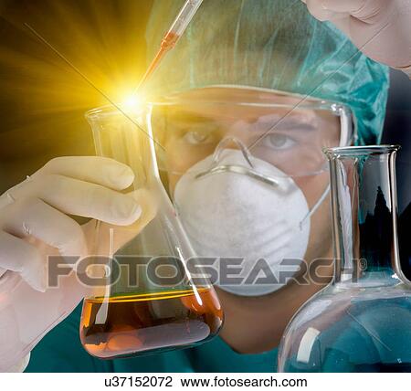 Stock Image - Scientist dropping liquid from pipette. Fotosearch