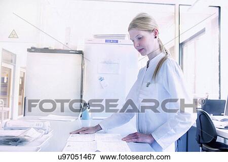 Scientist looking down at papers View Large Photo Image Stock Photo - Scientist looking down at papers. Fotosearch