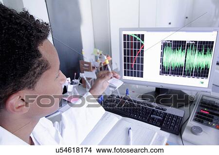 Picture - Scientist wearing lab coat working on computer. Fotosearch