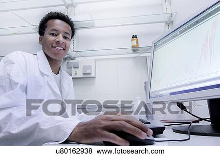 Stock Photo - Scientist wearing lab coat working on computer. Fotosearch