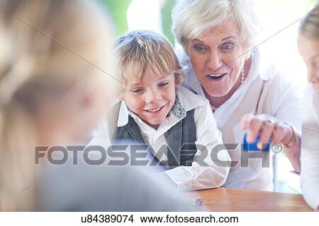 Senior female playing board game with grandchildren View Large Photo Image Picture - Senior female playing board game with grandchildren. Fotosearch