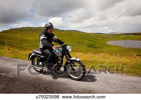 Senior male on motorbike on rural road View Large Photo Image Stock Photo - Senior male on motorbike on rural road. Fotosearch