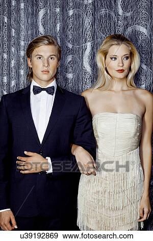 Serious young glamorous couple arm in arm View Large Photo Image Stock Photo - Serious young glamorous couple arm in arm. Fotosearch