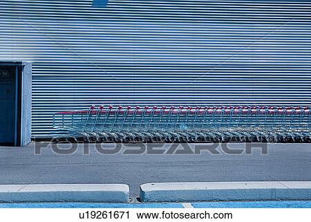 Stock Image - Shopping trolleys lined up outside supermarket. Fotosearch