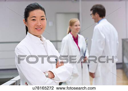 Stock Image - Small group of scientists in laboratory atrium. Fotosearch