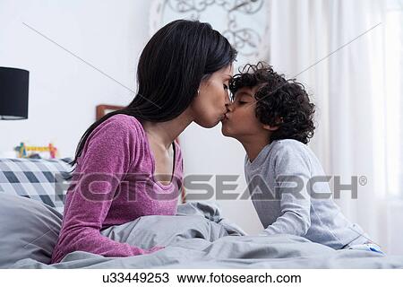 Son kissing mother in bed View Large Photo Image Stock Image - Son kissing mother in bed. Fotosearch