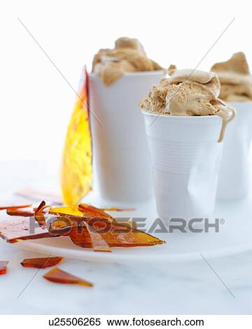 Stock Photography - Still life with cups of salted caramel ice cream and toffee shards. Fotosearch