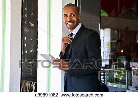 Stock Image - Stylish businessman with digital tablet. Fotosearch