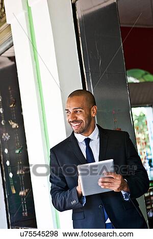 Stock Photo - Stylish businessman with digital tablet. Fotosearch