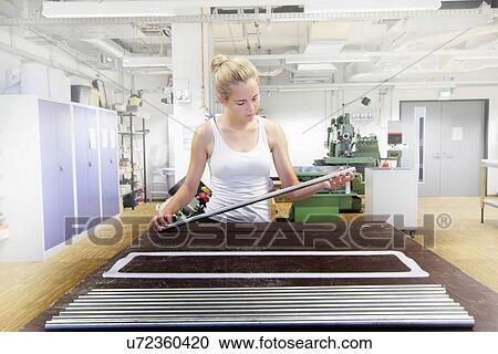 Stock Image - Technician working in optical laboratory. Fotosearch