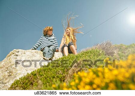 Teenage couple sitting on rocks View Large Photo Image Stock Photography - Teenage couple sitting on rocks. Fotosearch
