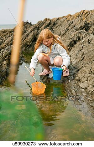 Teenage girl rock pooling View Large Photo Image Stock Image - Teenage girl rock pooling. Fotosearch