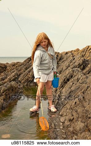 Stock Photography - Teenage girl rock pooling. Fotosearch