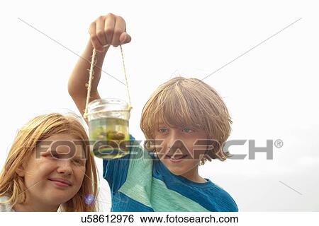 Teenagers holding jar View Large Photo Image Stock Photograph - Teenagers holding jar. Fotosearch