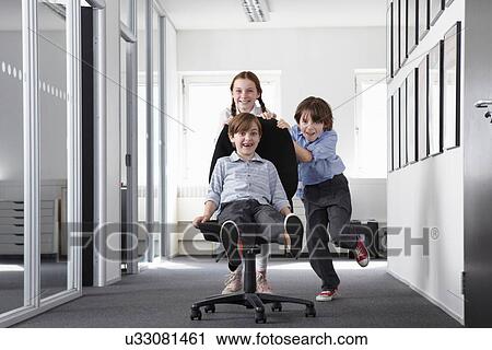 Three children playing in office corridor on office chair View Large Photo Image Stock Image - Three children playing in office corridor on office chair. Fotosearch