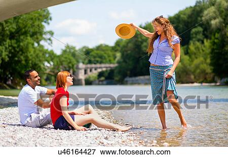 Three friends by Isar River, Munich, Germany View Large Photo Image Stock Photo - Three friends by Isar River, Munich, Germany. Fotosearch