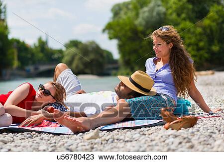 Three friends relaxing by Isar River, Munich, Germany View Large Photo Image Stock Image - Three friends relaxing by Isar River, Munich, Germany. Fotosearch