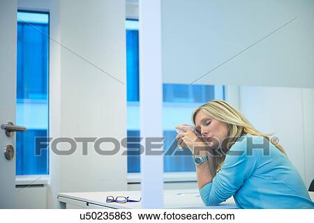 Tired businesswoman working late at office View Large Photo Image Stock Image - Tired businesswoman working late at office. Fotosearch