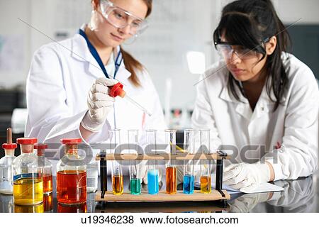 Two chemistry students doing experiment View Large Photo Image Stock Photo - Two chemistry students doing experiment. Fotosearch