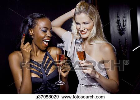 Stock Photo - Two female friends having fun in nightclub. Fotosearch