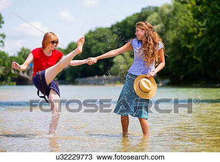 Two female friends playing in Isar River, Munich, Germany View Large Photo Image Stock Image - Two female friends playing in Isar River, Munich, Germany. Fotosearch