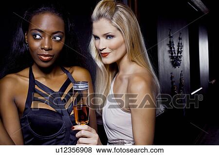 Two female friends watching in nightclub View Large Photo Image Stock Photo - Two female friends watching in nightclub. Fotosearch