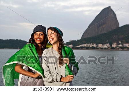 Two female friends wrapped in flag, Rio de Janeiro, Brazil View Large Photo Image Stock Image - Two female friends wrapped in flag, Rio de Janeiro, Brazil. Fotosearch
