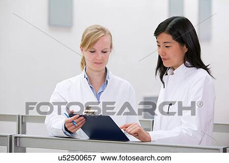 Two female scientists with clipboard View Large Photo Image Stock Photo - Two female scientists with clipboard. Fotosearch