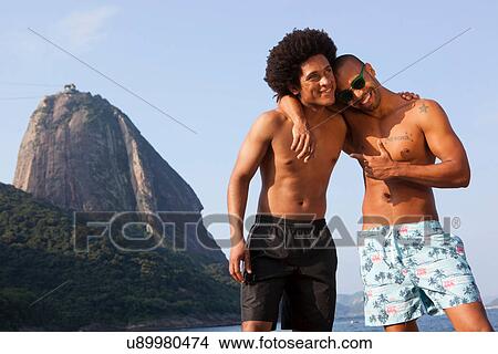 Two friends on beach with arms around each other, Rio de Janeiro, Brazil View Large Photo Image Picture - Two friends on beach with arms around each other, Rio de Janeiro, Brazil. Fotosearch